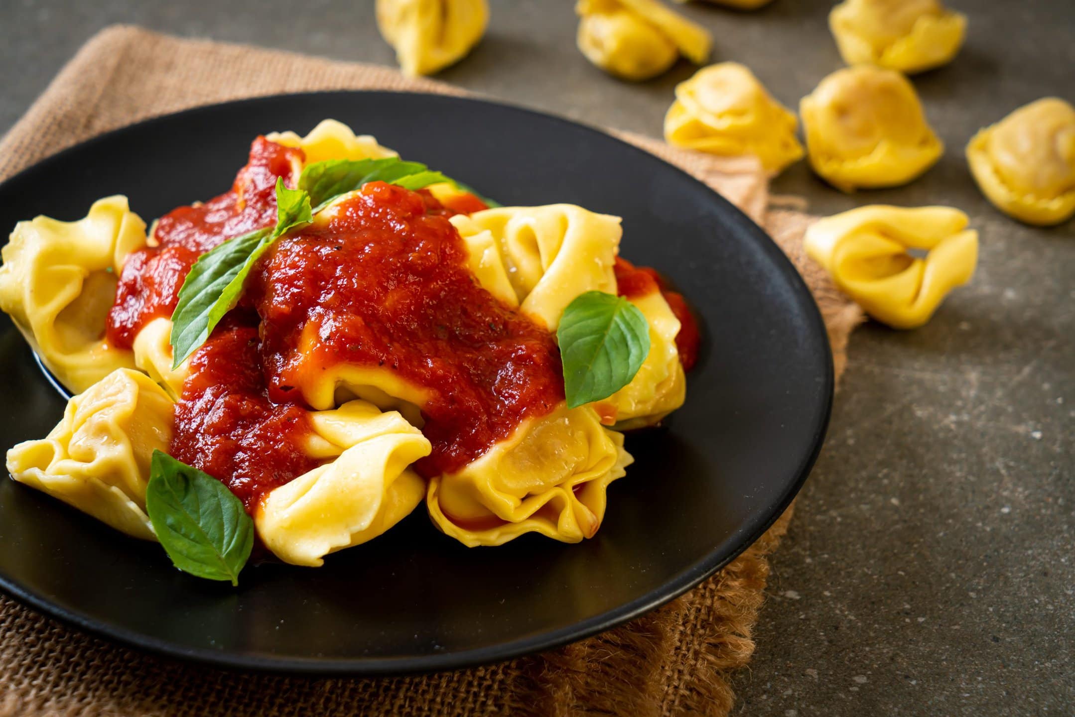 Tortellini with tomato sauce and basil leaves