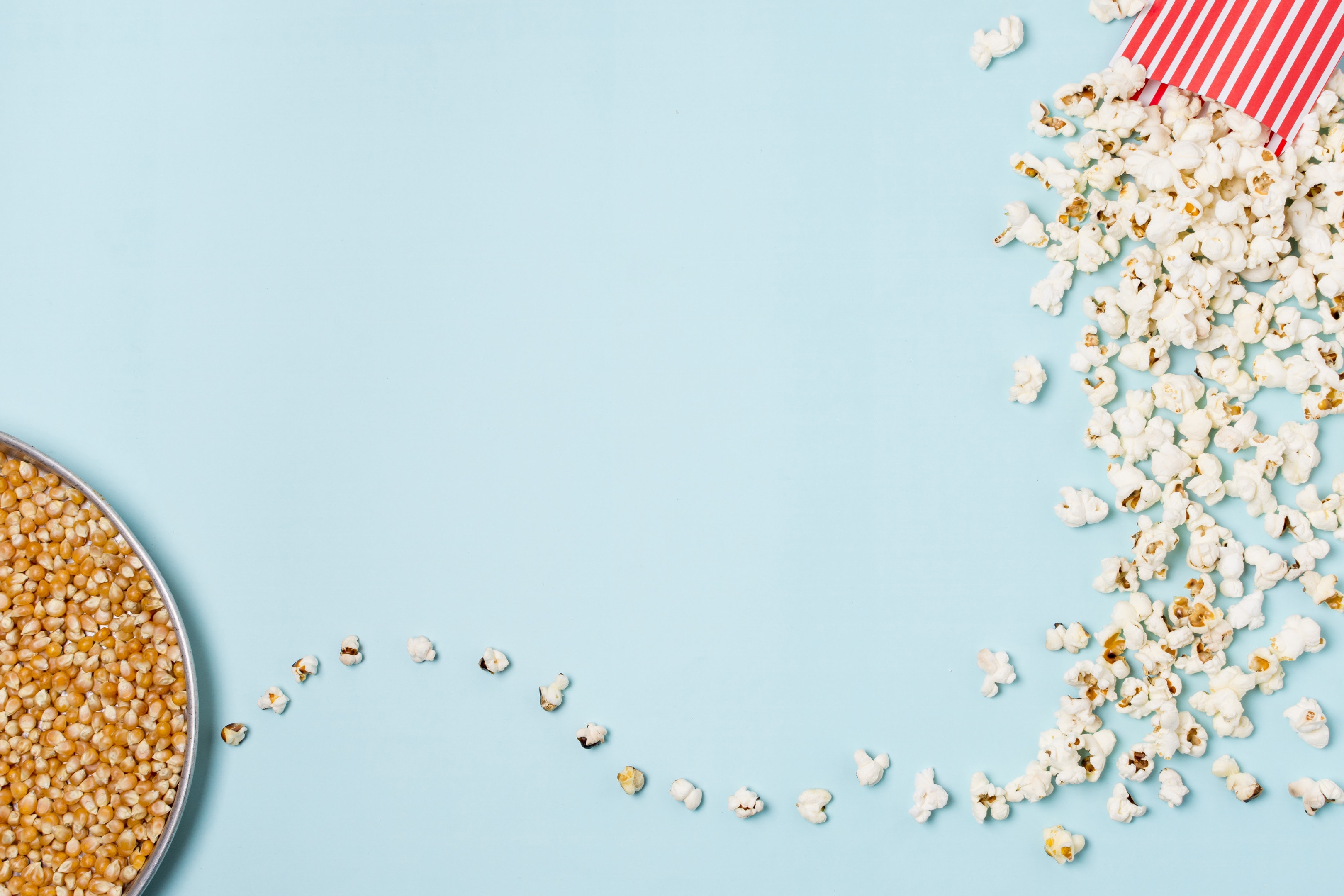 Corn seeds plate with popcorn spilled from box