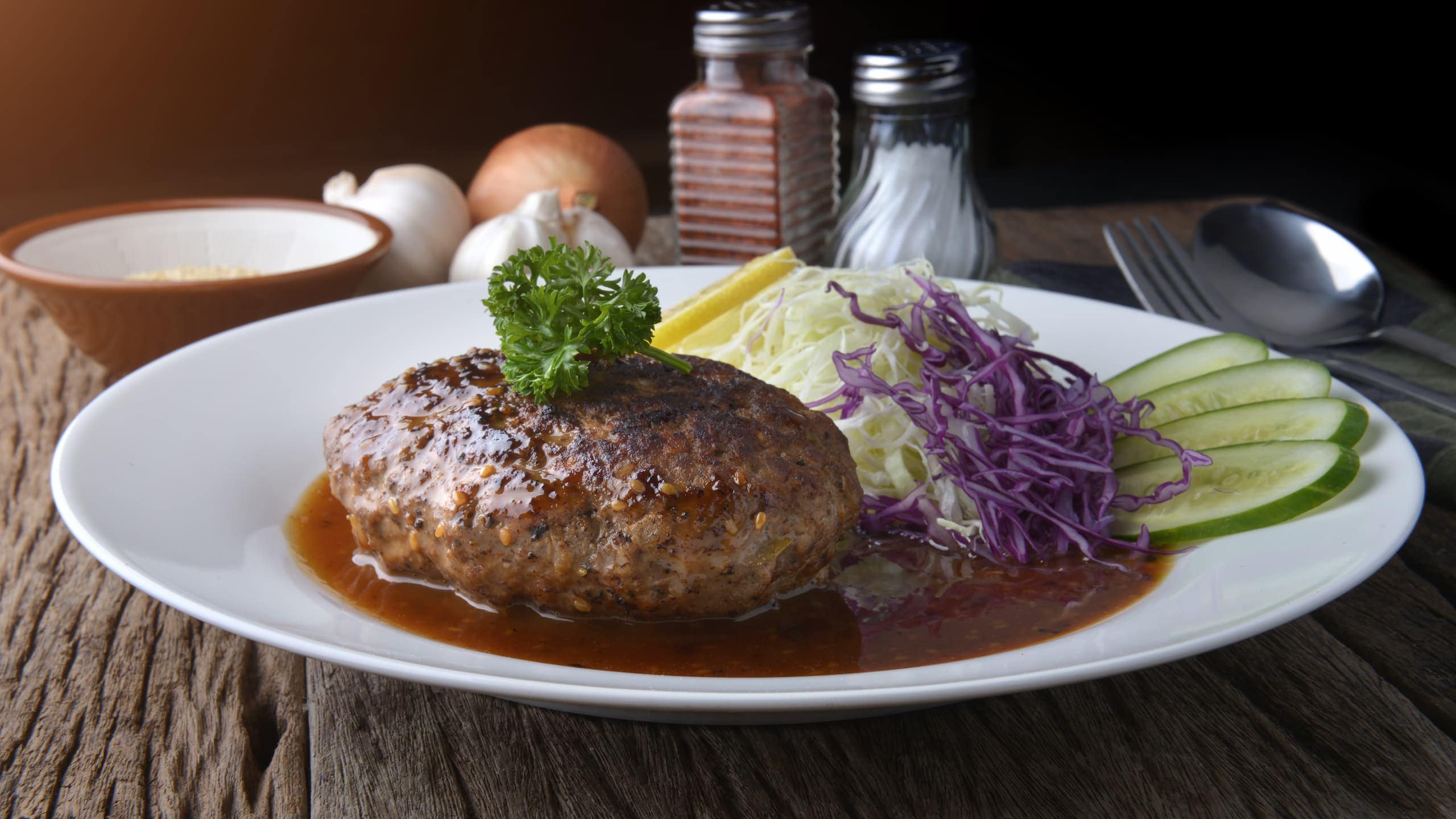 Cracker Barrel hamburger steak with lettuce, lemon, cucumber, and gravy