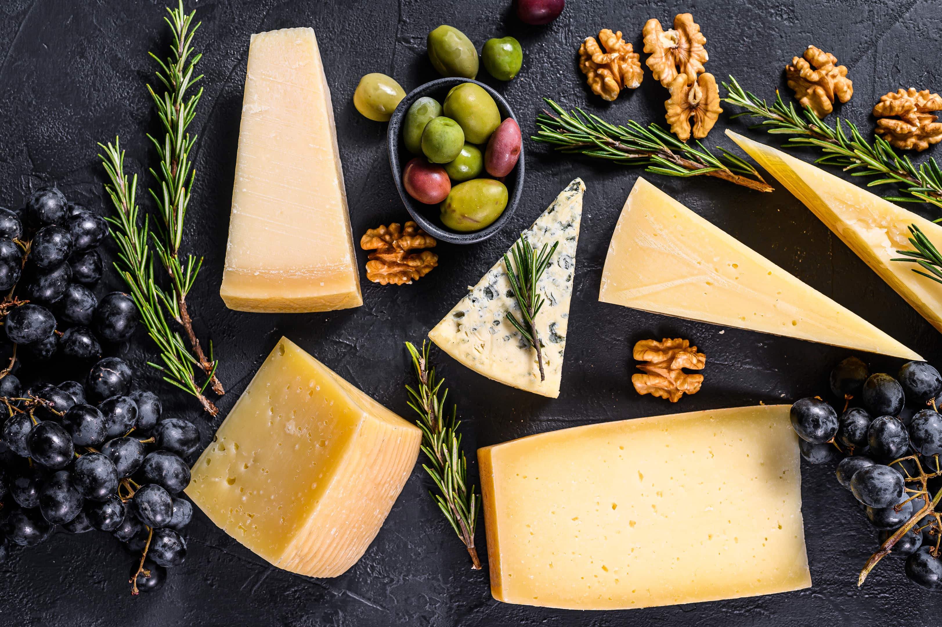 Different types delicious cheese with walnuts and grapes