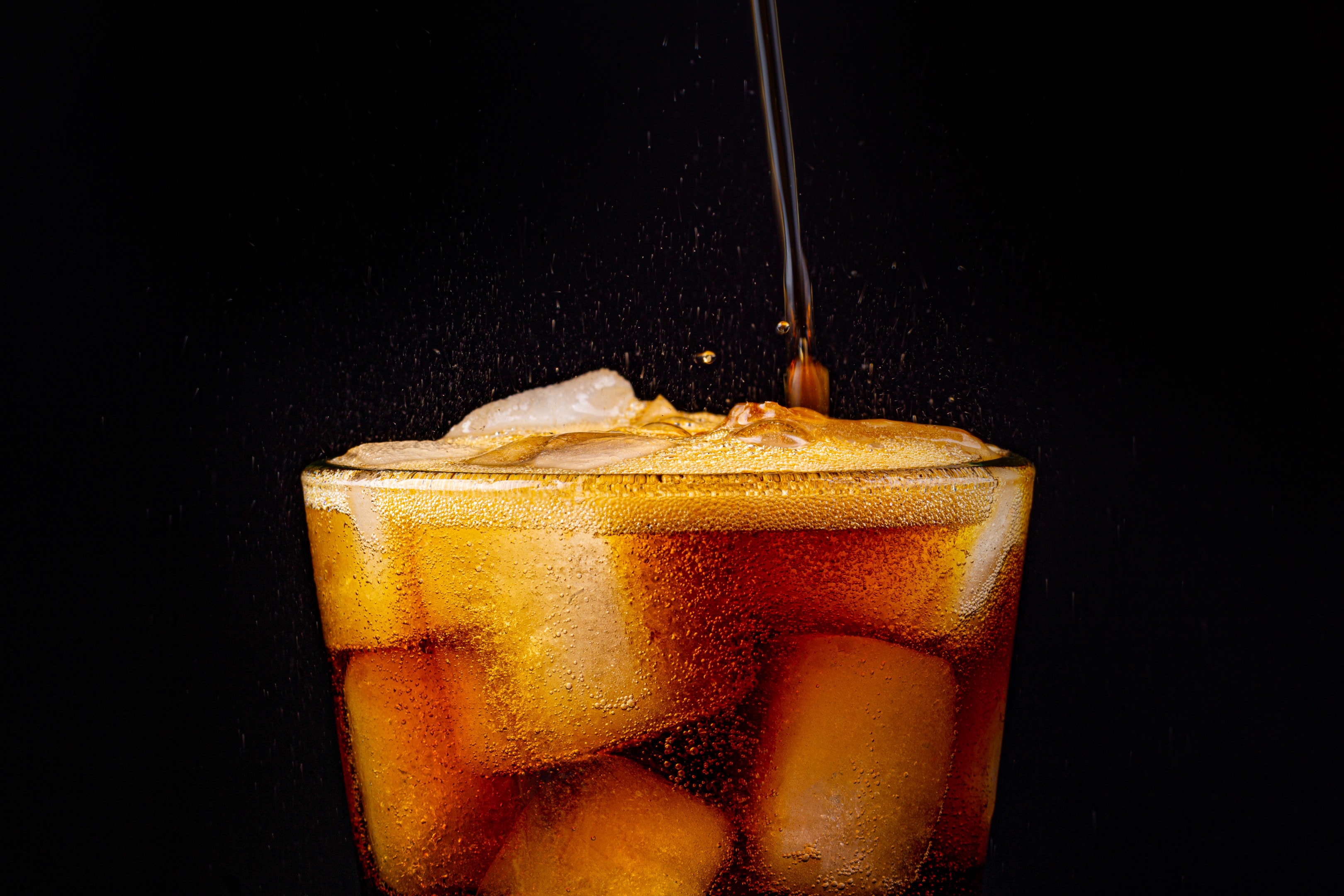 Sparkling cola with ice cubes