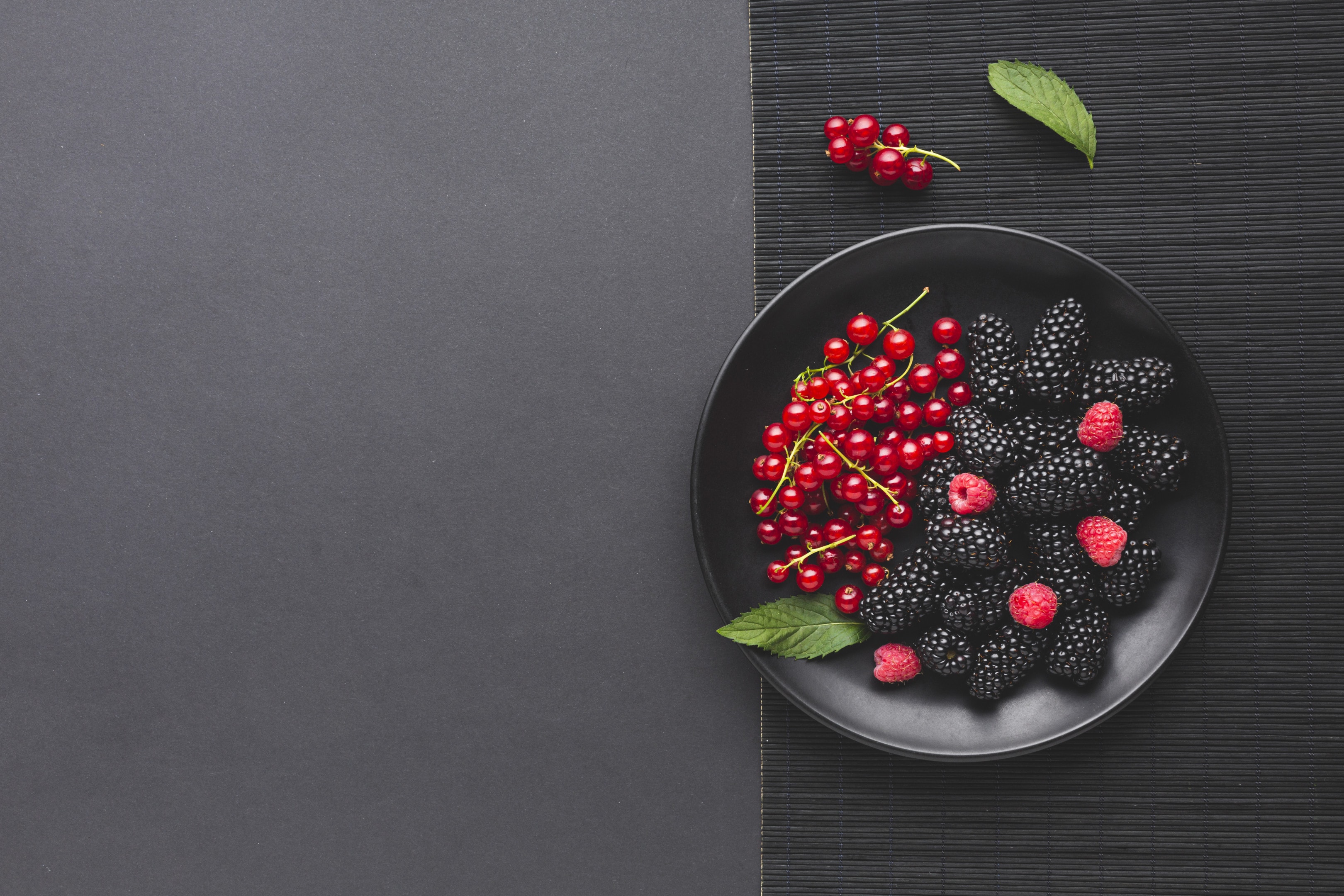 Flat lay plate of fresh berries on wooden table