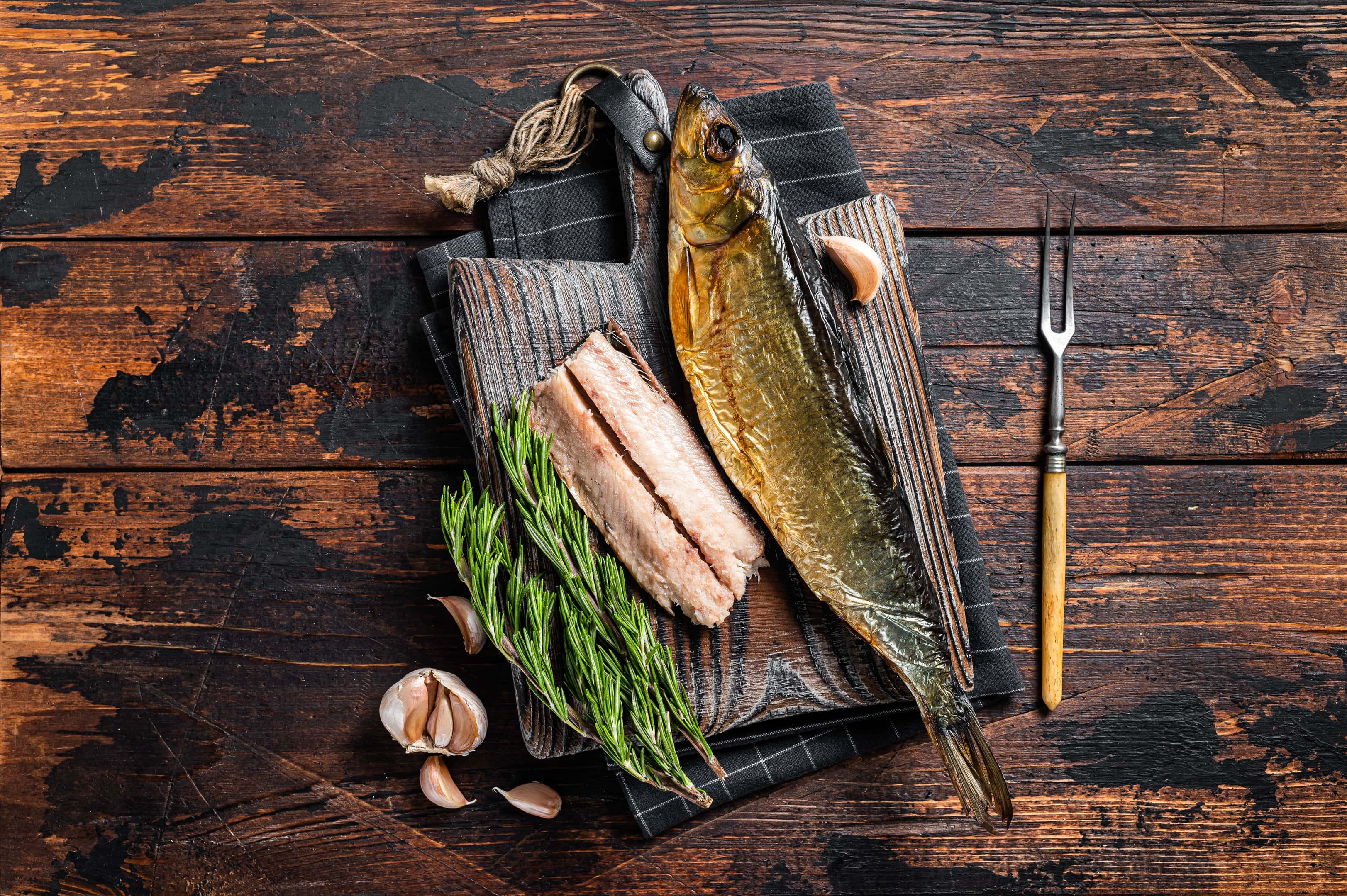 Fragrant smoked kipper fish fillet on a wooden board