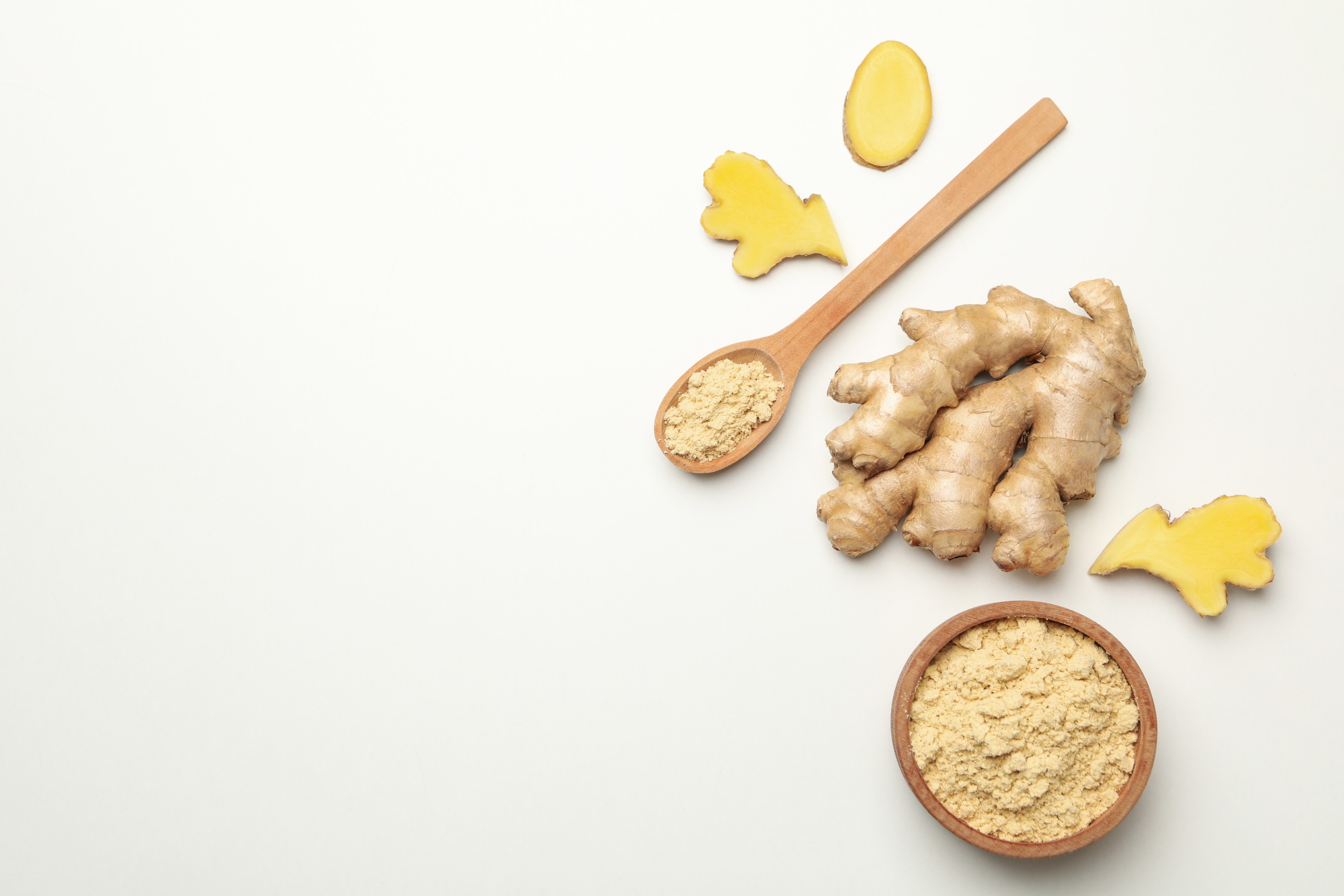 Fresh Ginger and Bowl of Ginger Powder on White Background