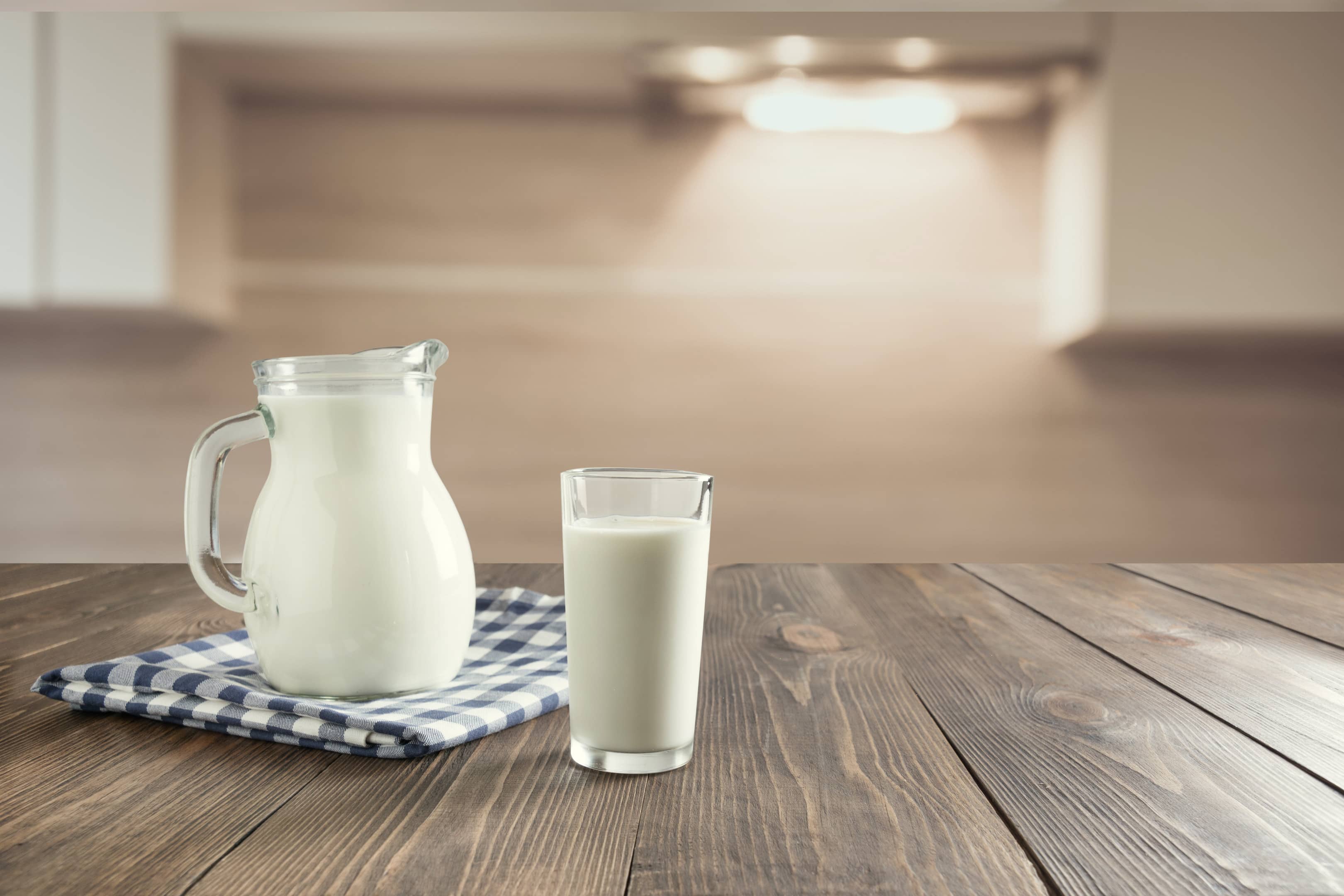 Glass and pitcher of fresh goat milk