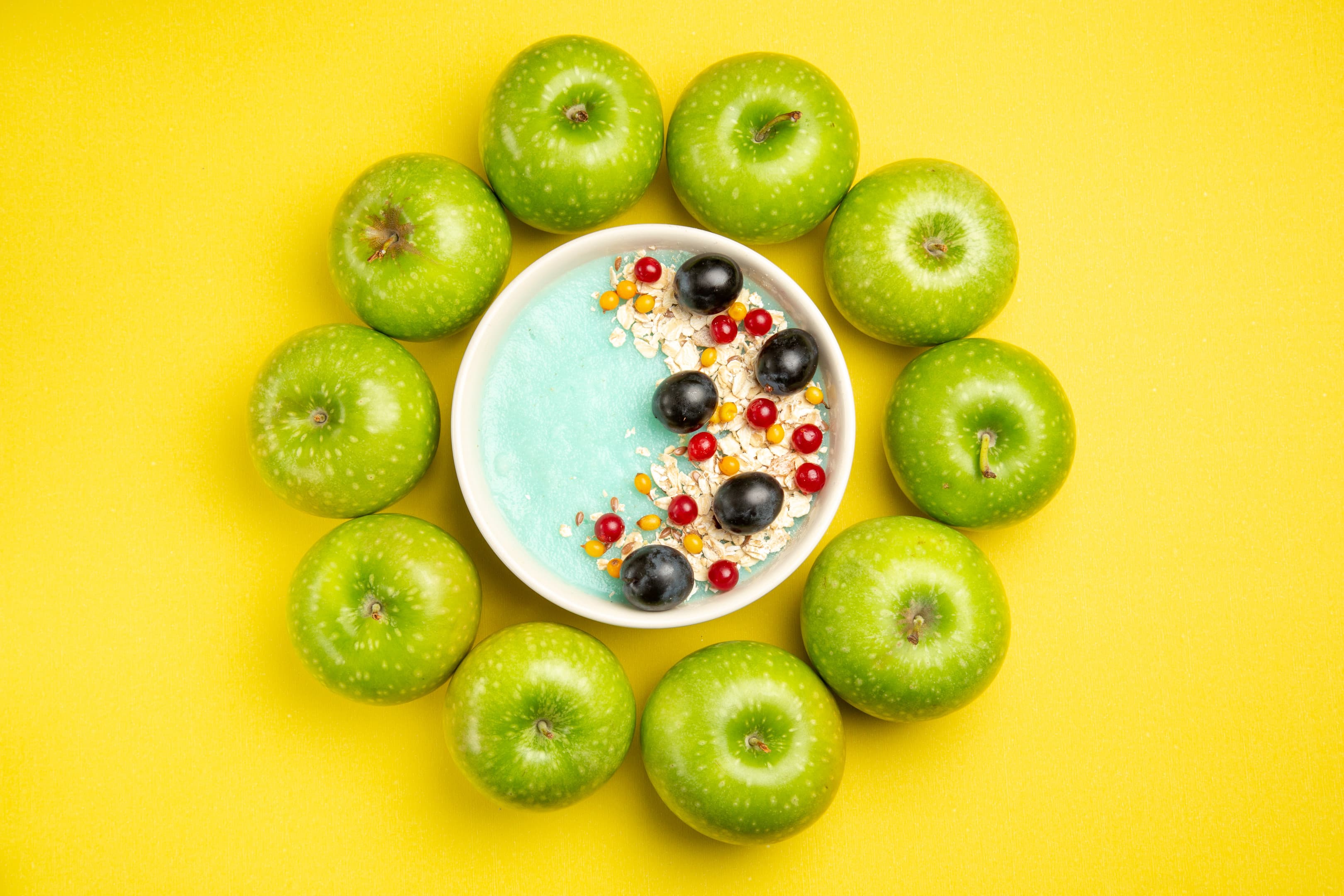 Granola &amp; yogurt bowl with apples, red grapes and berries