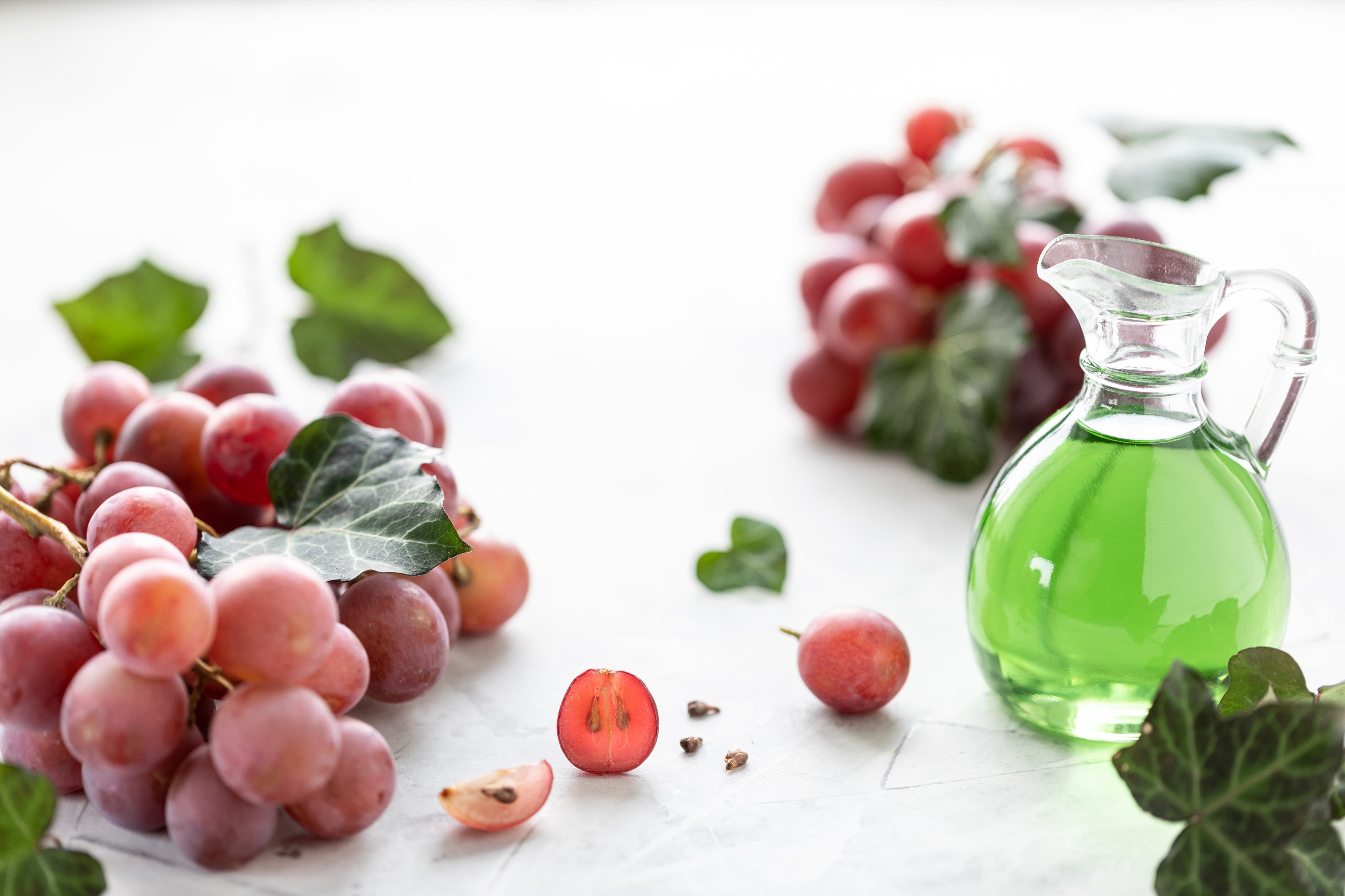 <a href="https://blend-of-bites.ghost.io/grape-seed-extract-adhd/" target="_blank" rel="noreferrer noopener">Grape seed extract</a> in a glass bottle with bunch of fresh grapes