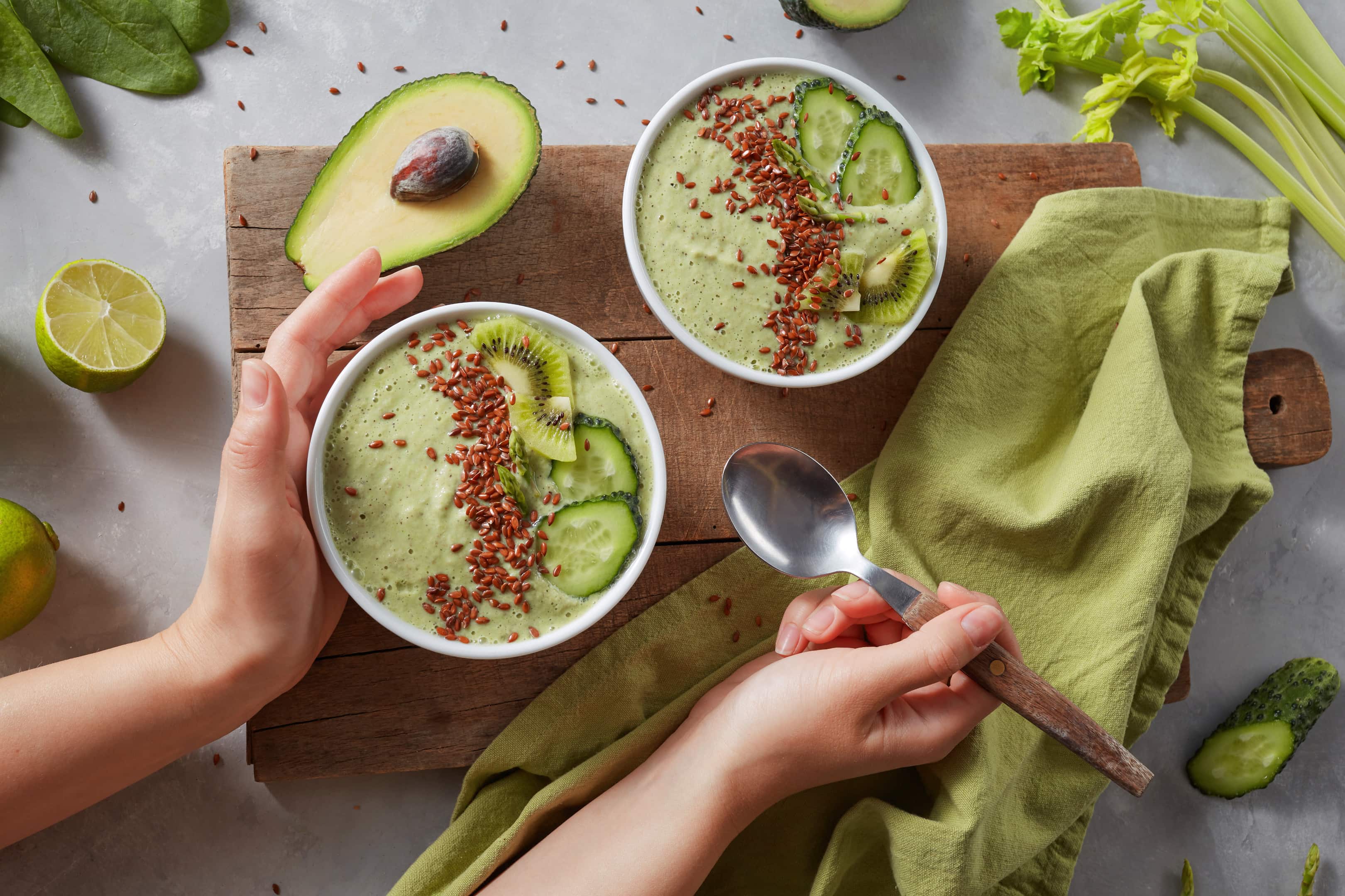 Green smoothie bowls with fresh kiwi, flaxseeds, cucumber and avocado