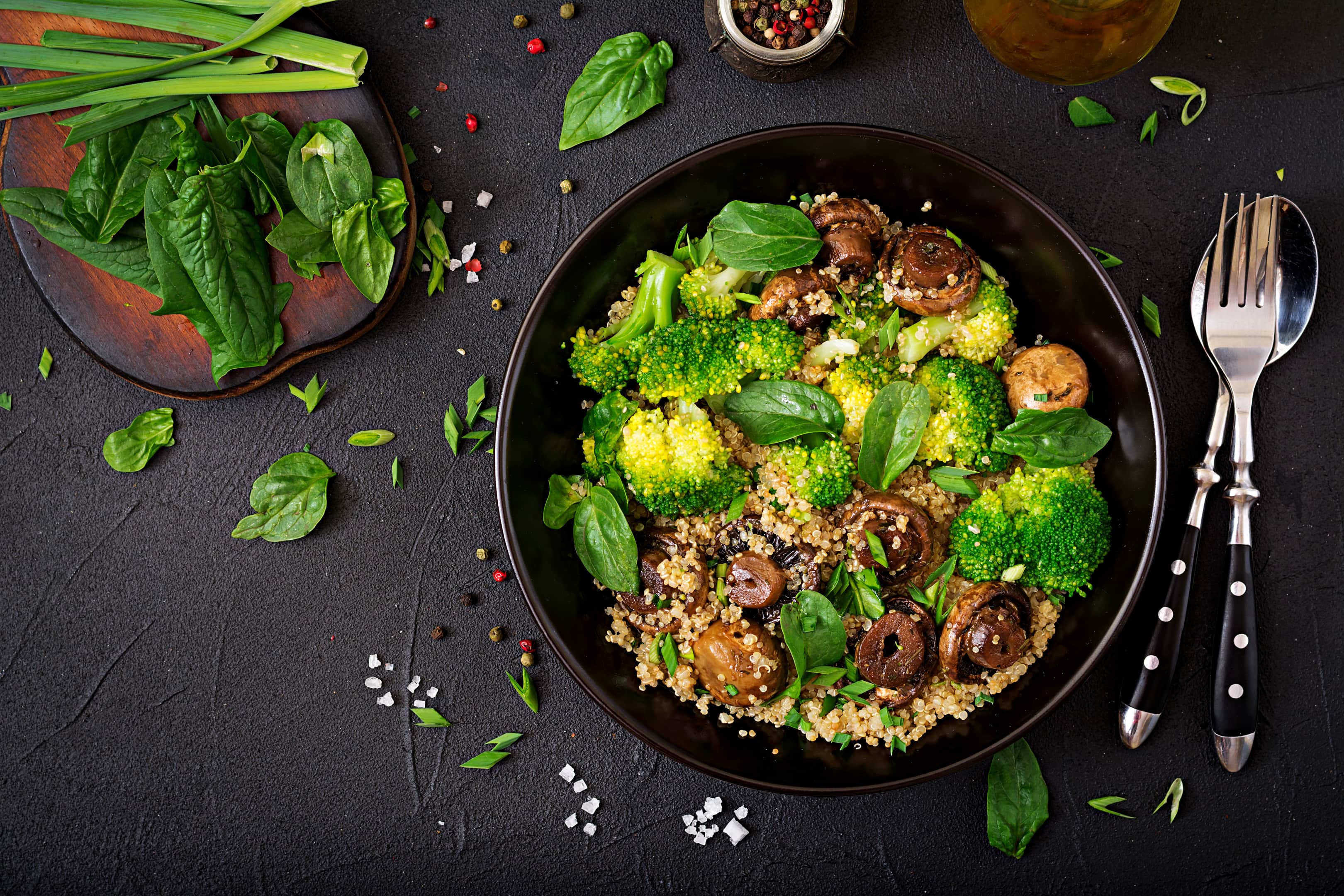 Healthy vegan salad of vegetables — broccoli, mushrooms, spinach and quinoa in a bowl