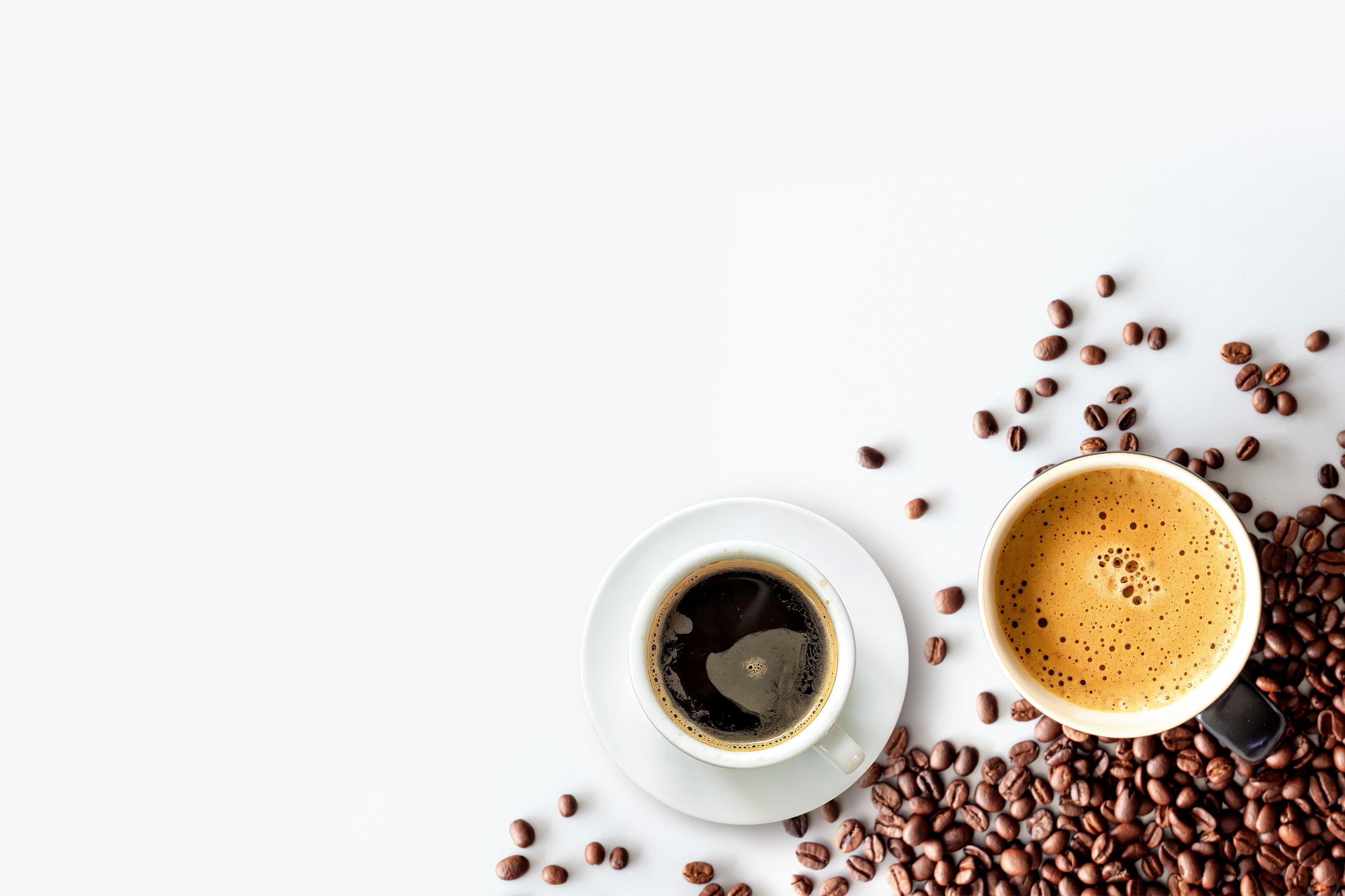 Hot espresso coffee cup and coffee beans on white table