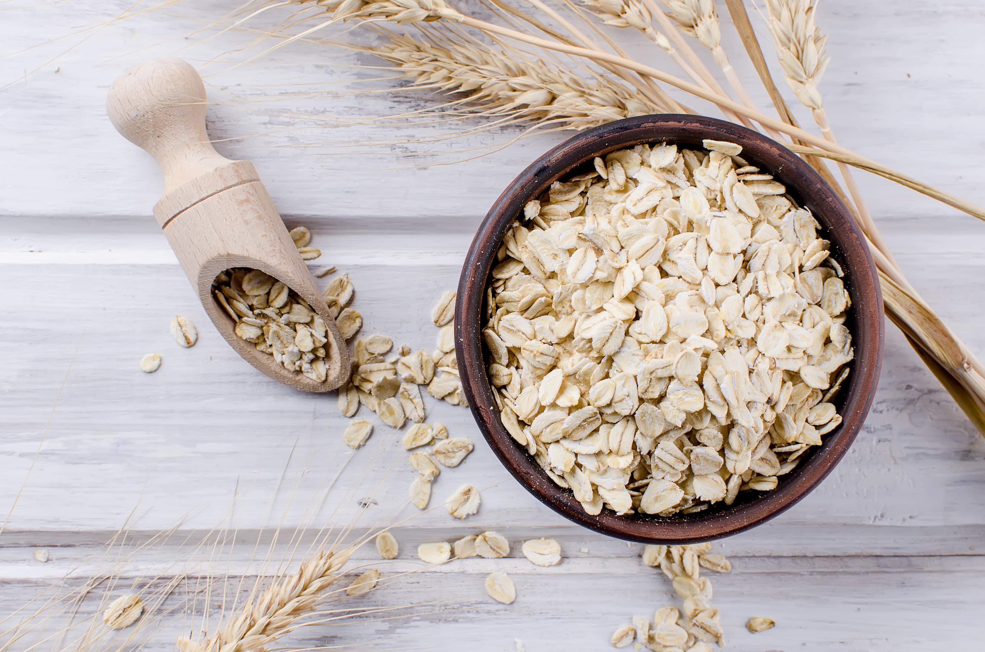 Oat flakes in ceramic bowl on wooden table