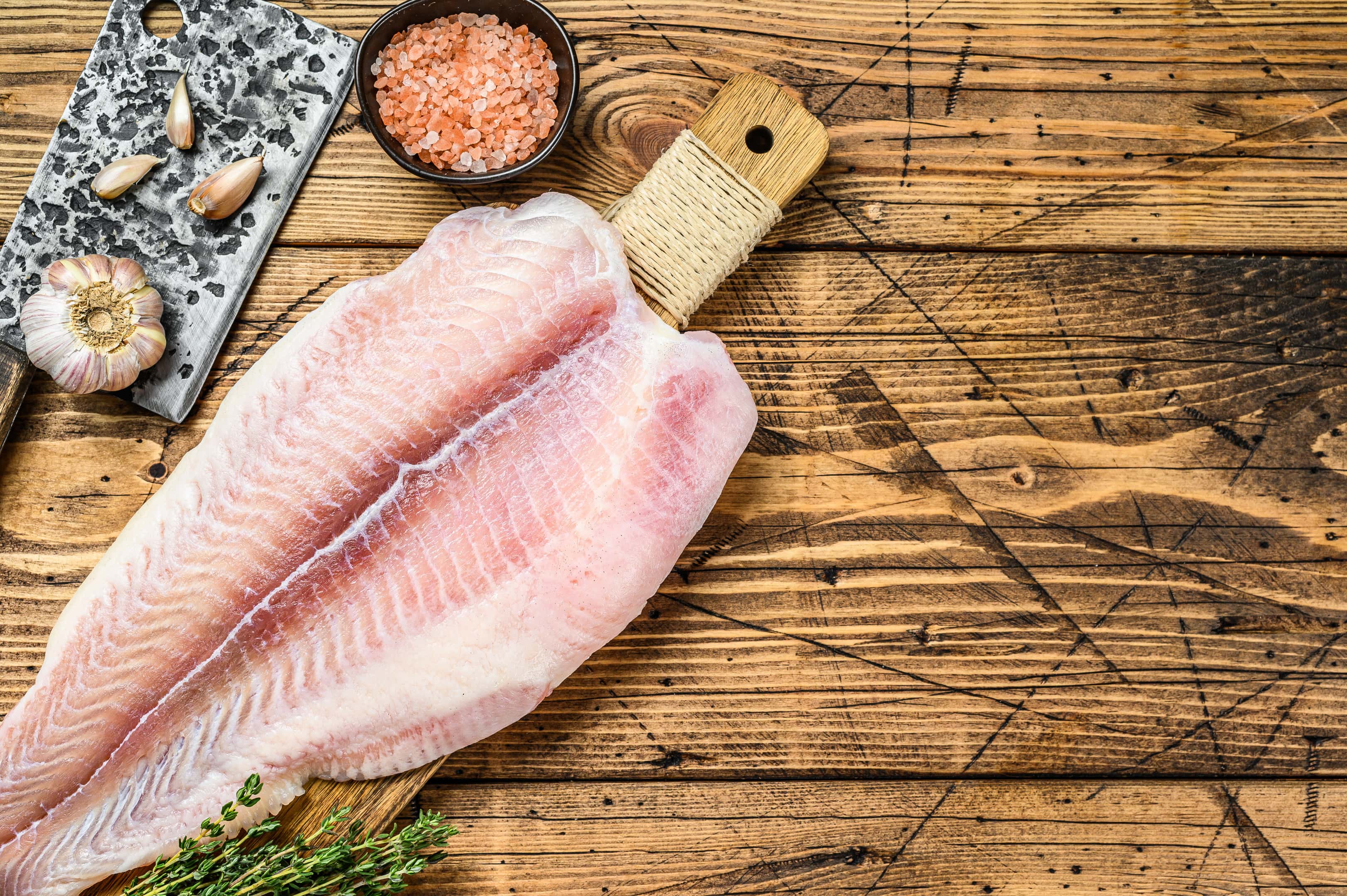 Raw Fillet of Cod Fish on Cutting Board