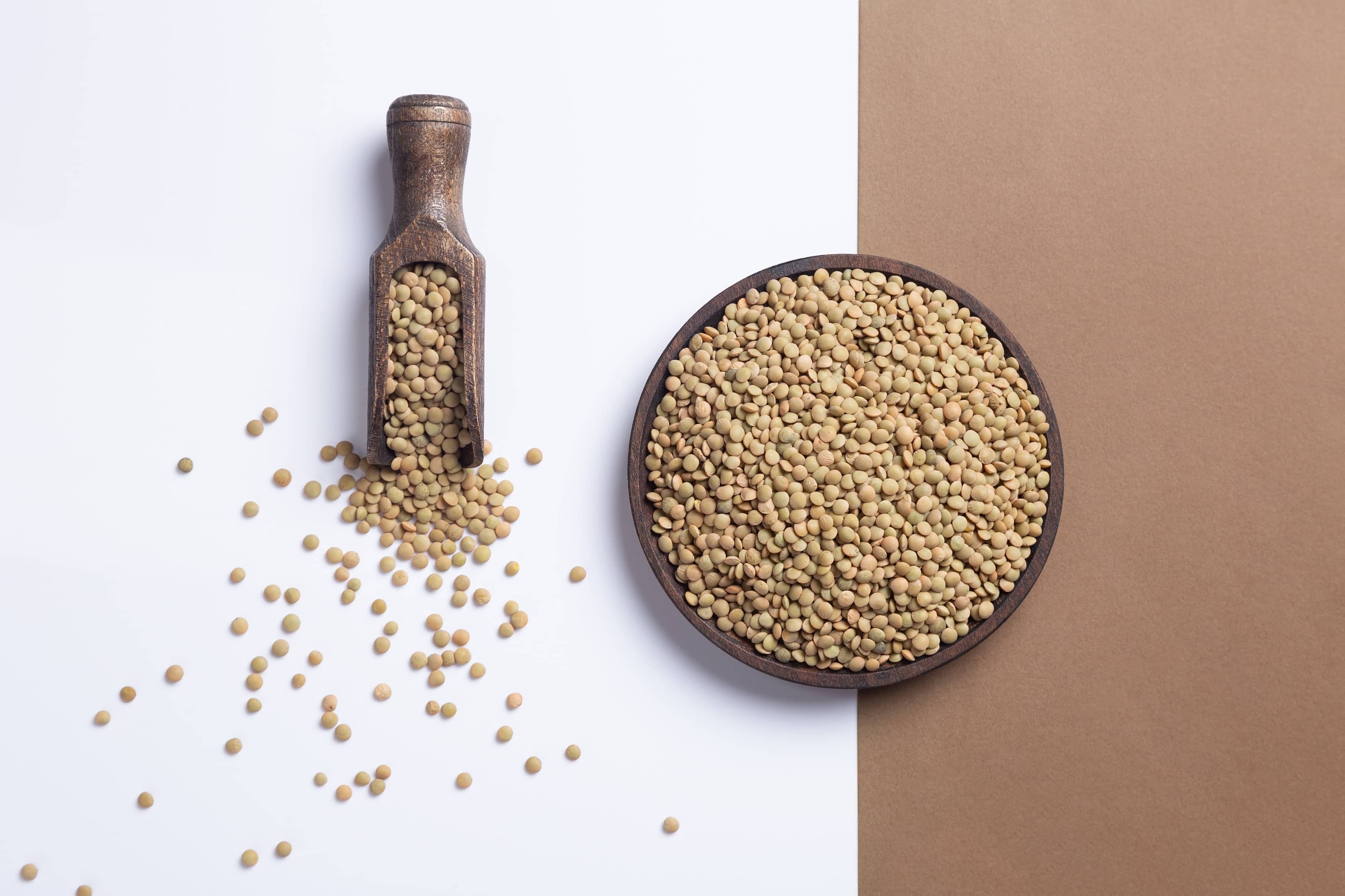 Raw lentils in wooden plate