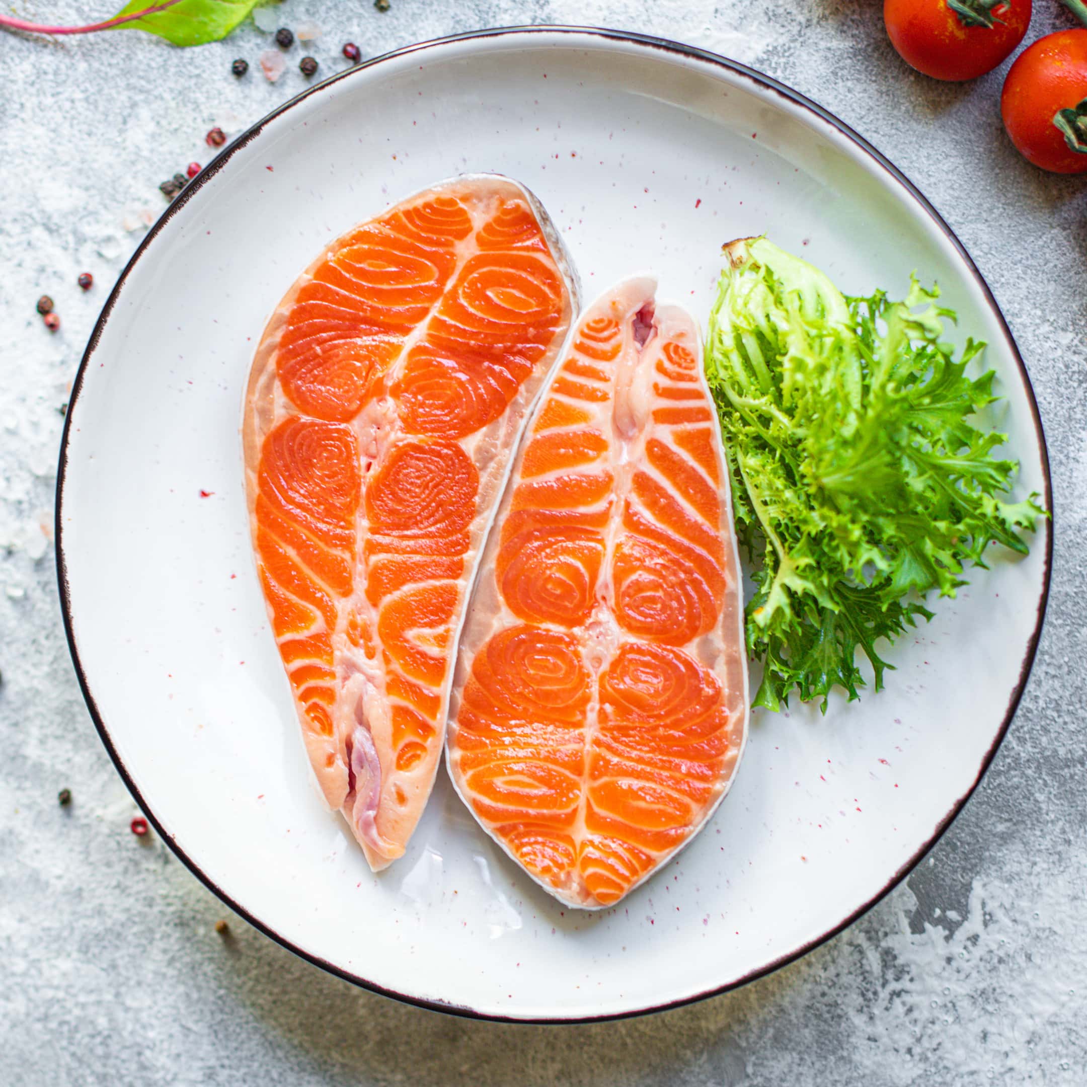 Raw salmon steak with greens