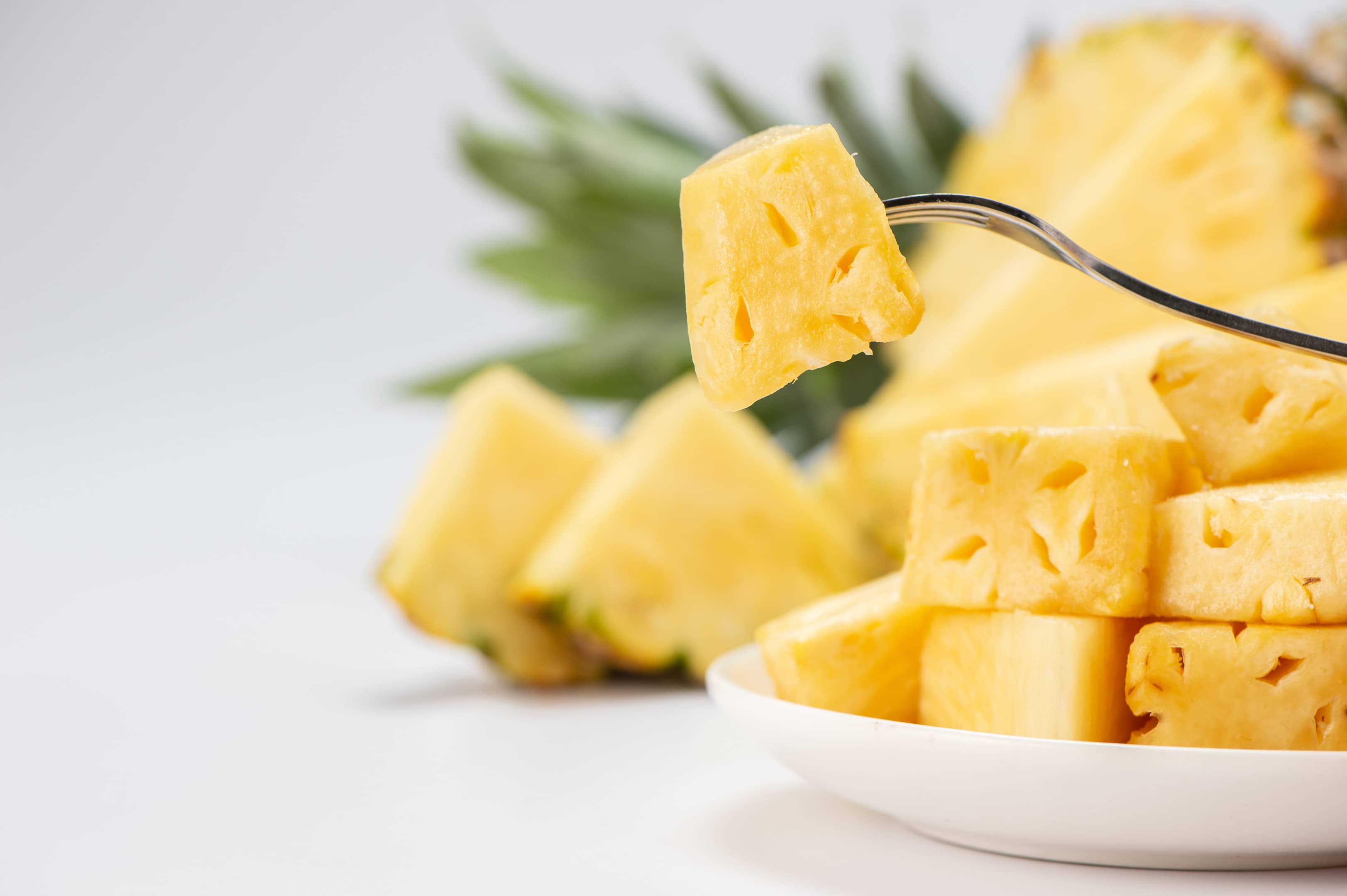 Sliced fresh pineapple on a fork
