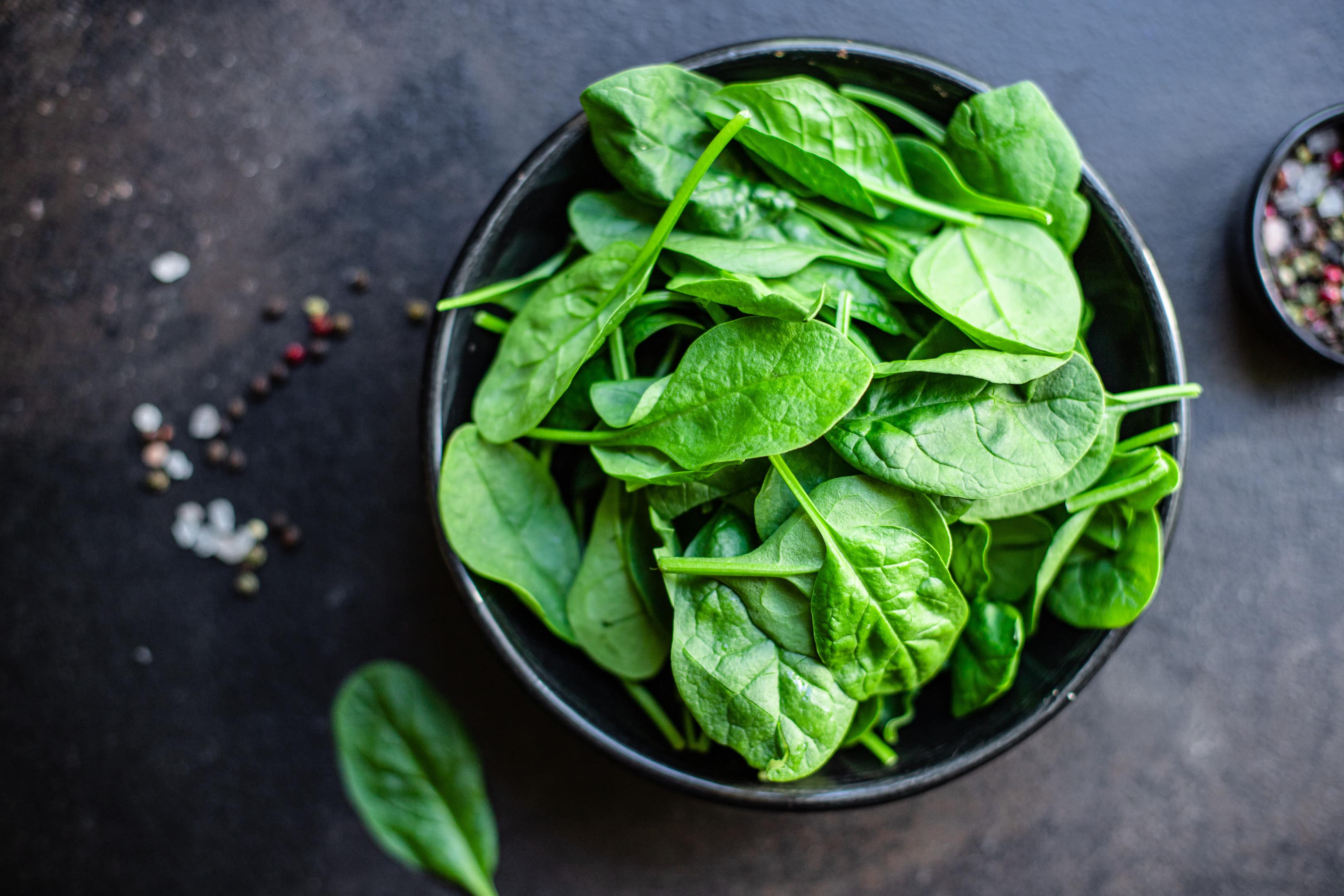 Spinach leaves in ceramic plate on kitchen table