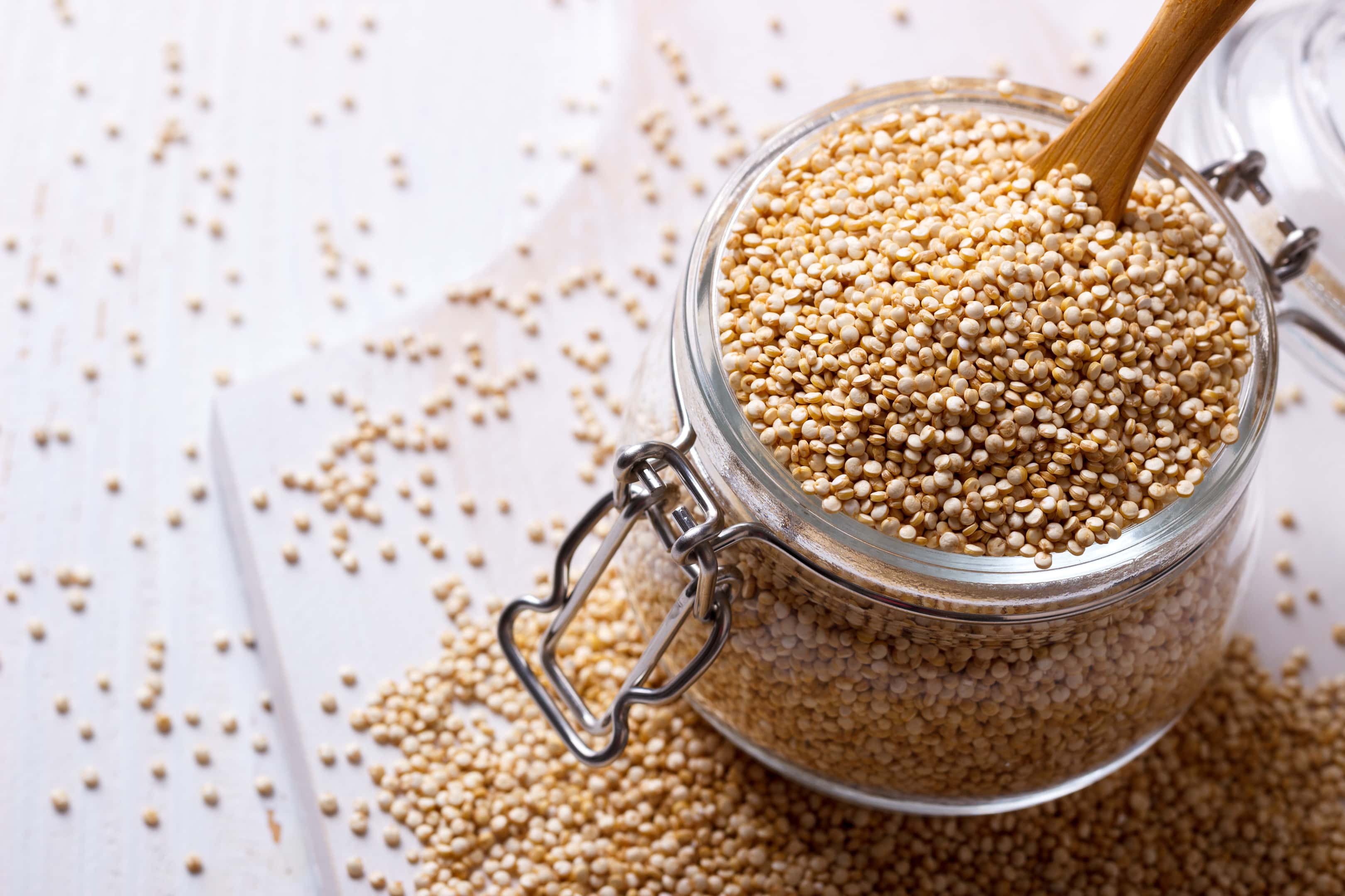 White quinoa seeds in glass jar