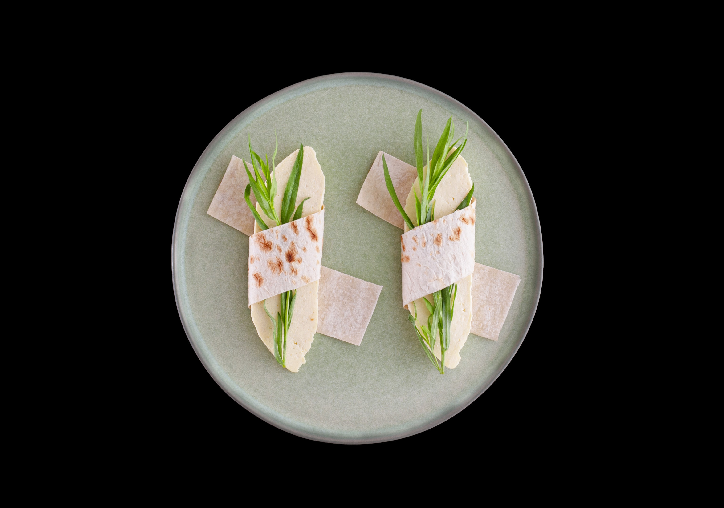 Wrapped pita bread with homemade cheese and semi-dry tarragon leaves