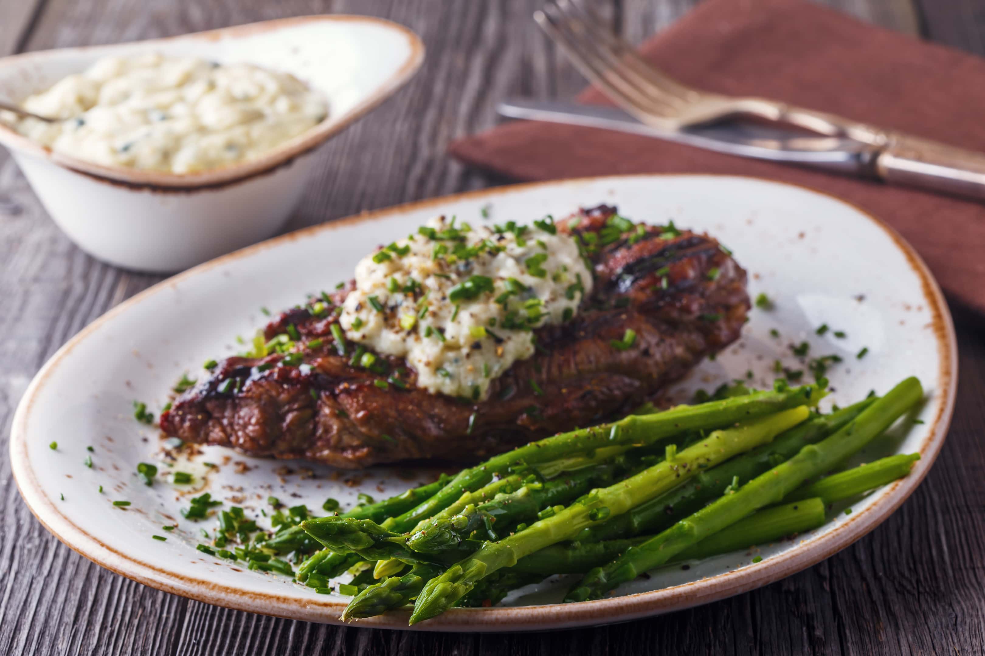 Steak with melted cheese and asparagus