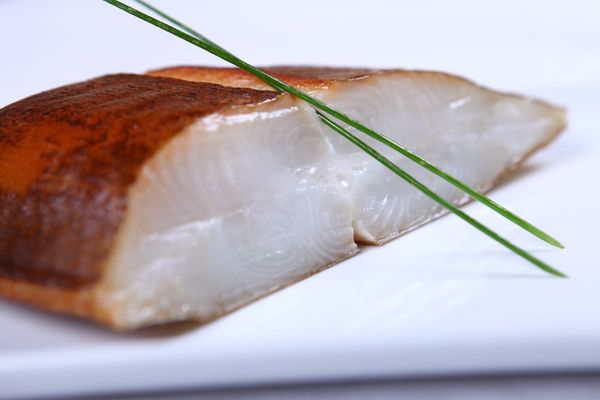 White fish fillet garnished with spring onion and lime