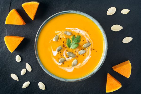 Creamy butternut squash soup with butternut squash slices and seeds