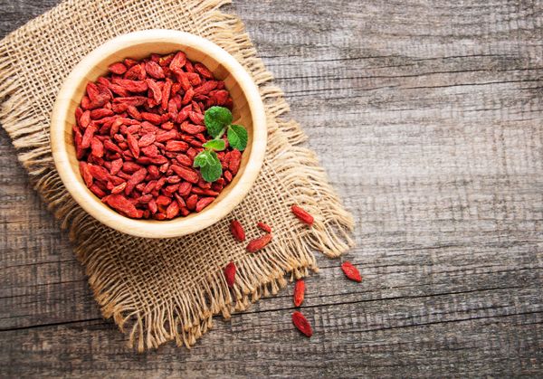Dry red goji berries in wooden bowl
