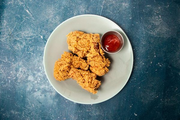 Crispy fried chicken on a plate with dipping sauce