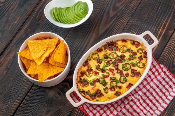 Cheesy jalapeño dip topped with bacon and chips