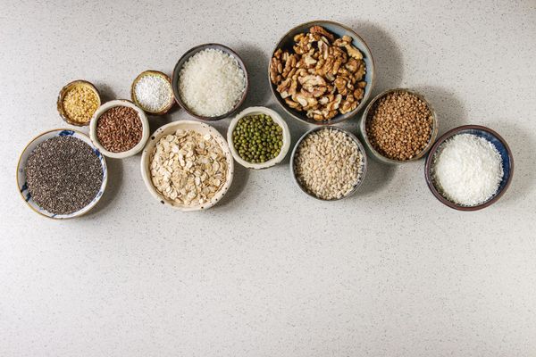 Variety of raw uncooked grains including wheat, buckwheat, oatmeal, and rice