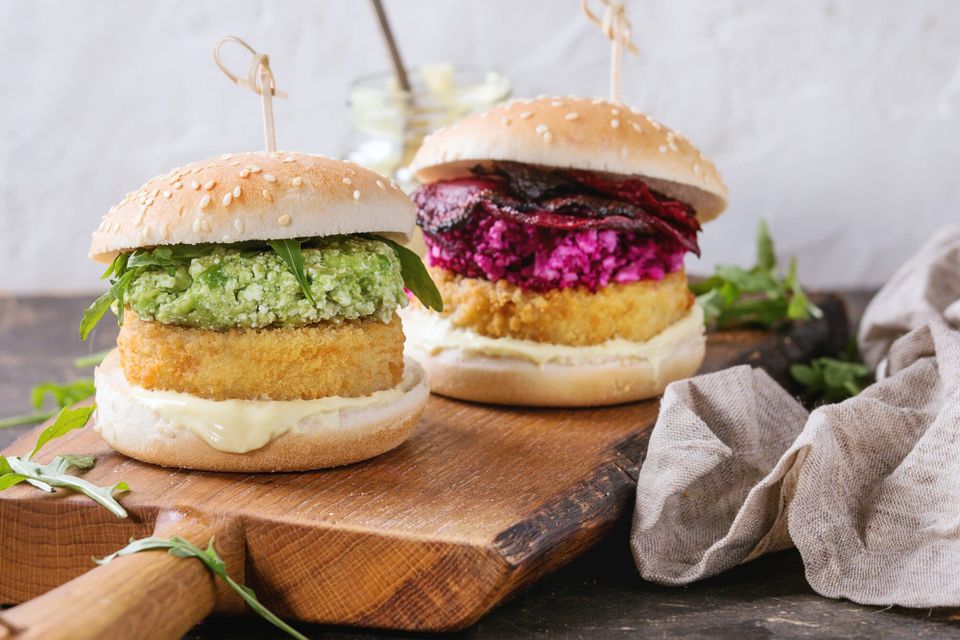 Vegan burgers on buns with avocado and beetroot toppings