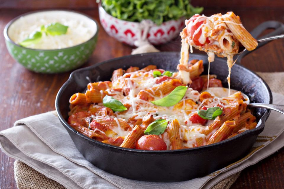 Pasta with Cajun Alfredo sauce, served with tomatoes and greens