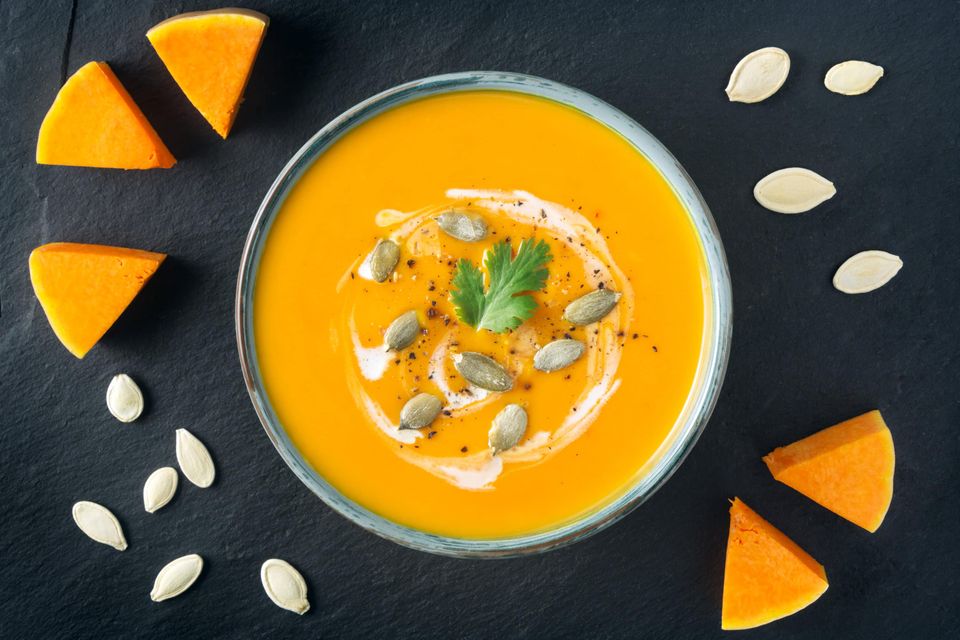Creamy butternut squash soup with butternut squash slices and seeds
