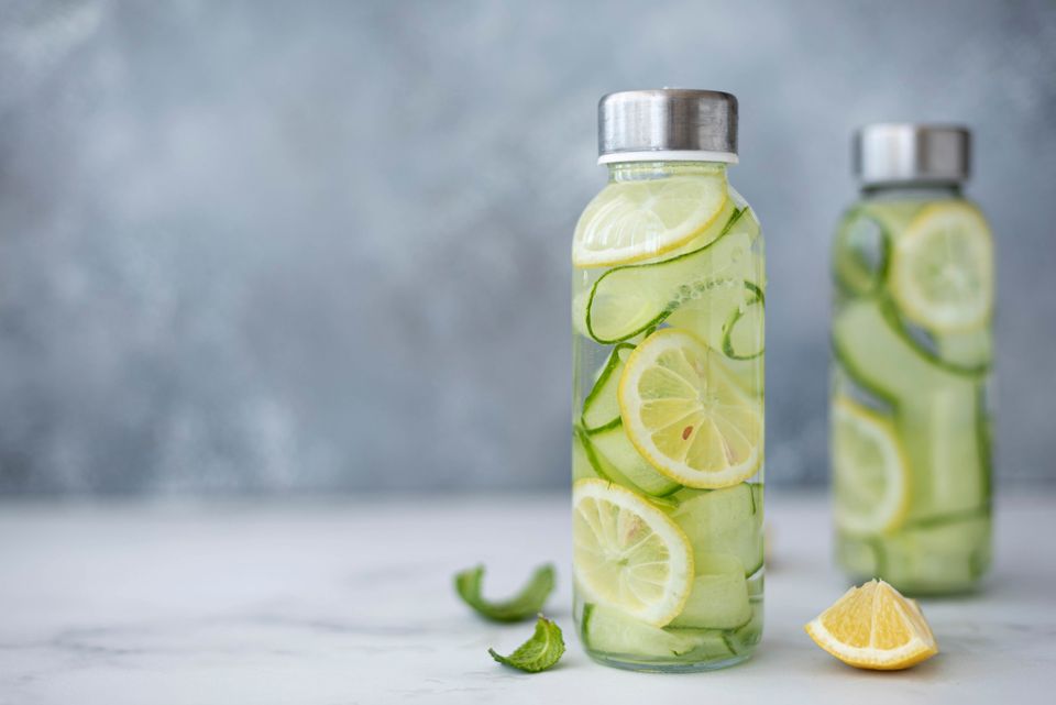 Detox water with cucumber, lemon and mint in a glass bottle