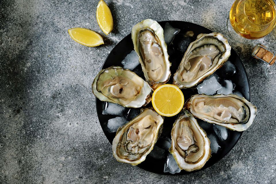 Fresh oysters with lemon slices on plate
