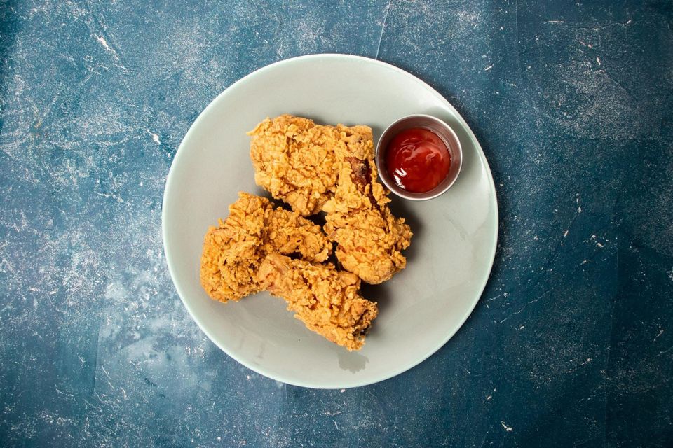 Crispy fried chicken on a plate with dipping sauce