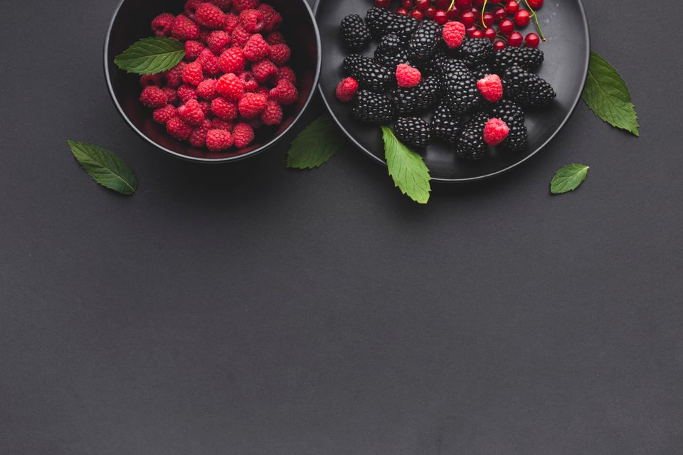 Plate and Bowl of Fresh Berries on Dark Table