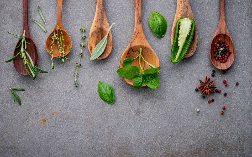 Various spices and herbs on wooden spoons