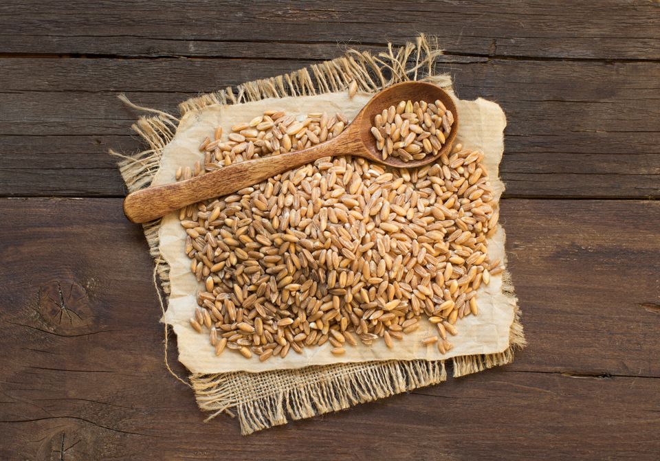 Spelt grains with a wooden spoon
