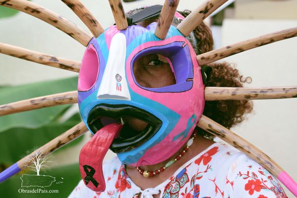 Wilda Cruz utilizando una máscara de vejigante en coco con nariz blanca y lengua pronunciada