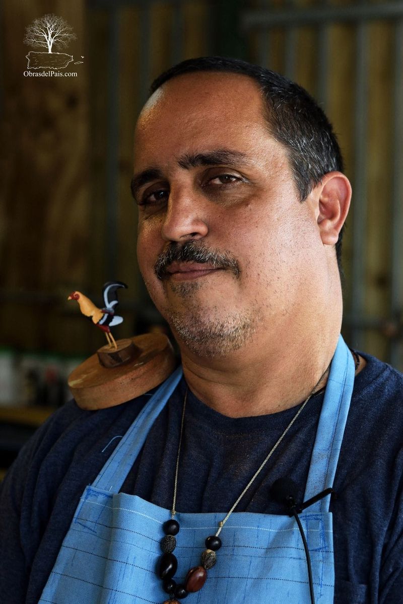 Carlos Teissonniere Comas mostrando una talla de gallo en madera