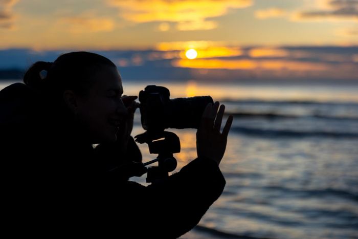Professional photographer using precision calculators to plan depth of field, exposure and print sizing for a shoot