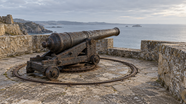 A weathered cannon on a circular iron track faces the sea from a stone coastal fort. (AI-generated image)
