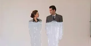 A man and a woman stare at each other as their clothes are colored in from top to bottom in the film Eight Postcards from Utopia