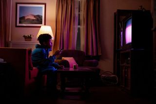 A young man watches TV in the film I Saw the TV Glow