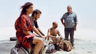 The cast of Sirat sitting in the desert