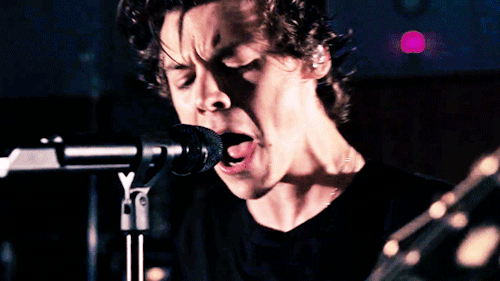  An animated gif of Harry Styles singing at a microphone. 
