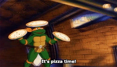  An animated gif of the Teenage Mutant Ninja Turtle Michaelangelo carrying three pizzas—one in each hand, one on his head—and saying “It’s pizza time!” 