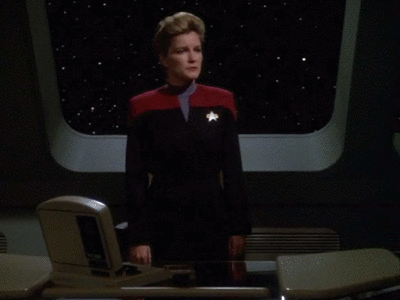  An animated gif by Swear Trek in which Captain Janeway leans seriously on a conference table. The noncanonical caption is “I’ve been druk since Saturday.” 