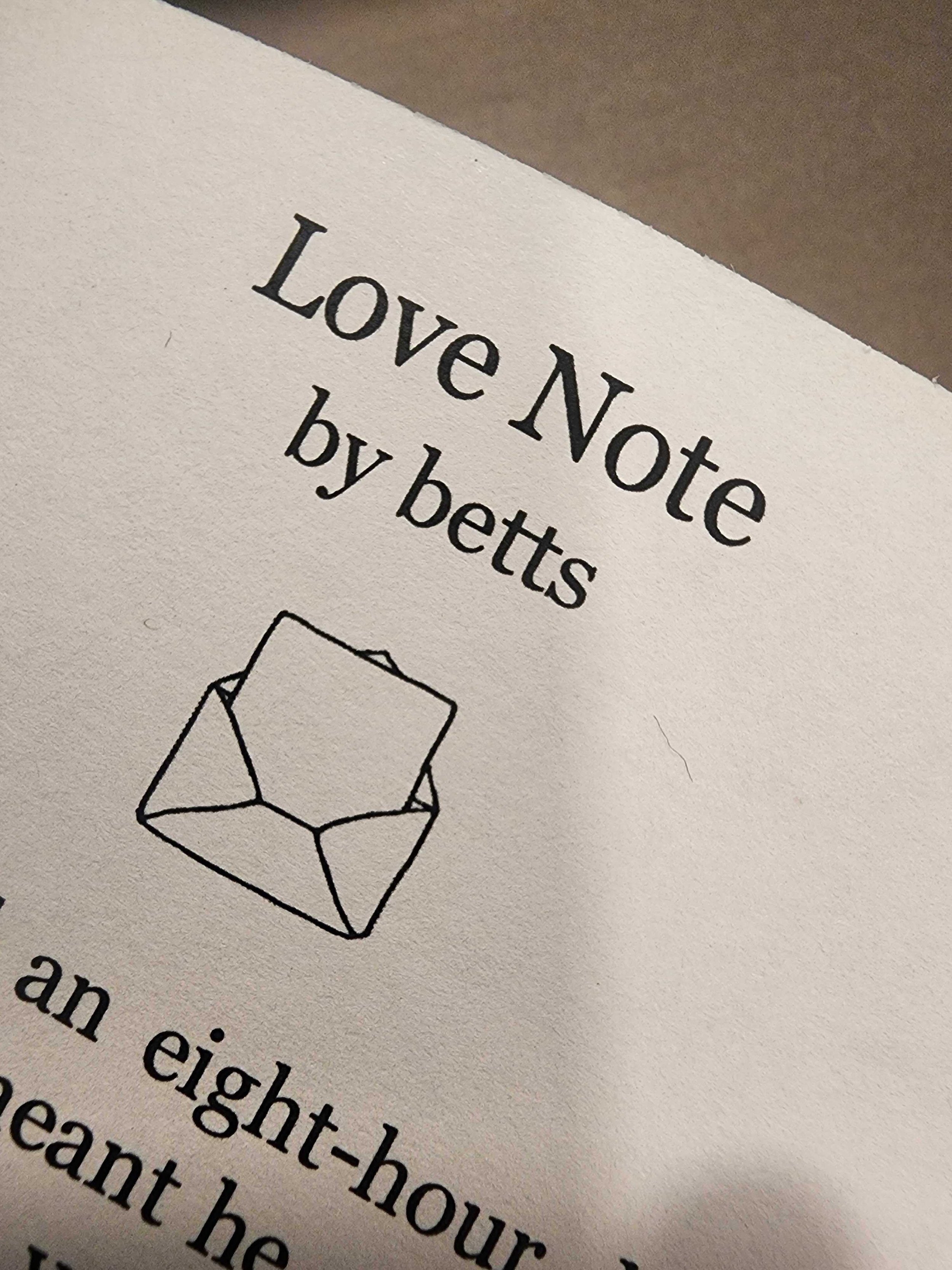 Photo of a page from the Tiny Zine. Text reads "Love Note by betts" followed by an illustration of a letter in an envelope. A few letters from the first line of the ficlet are visible at the bottom.