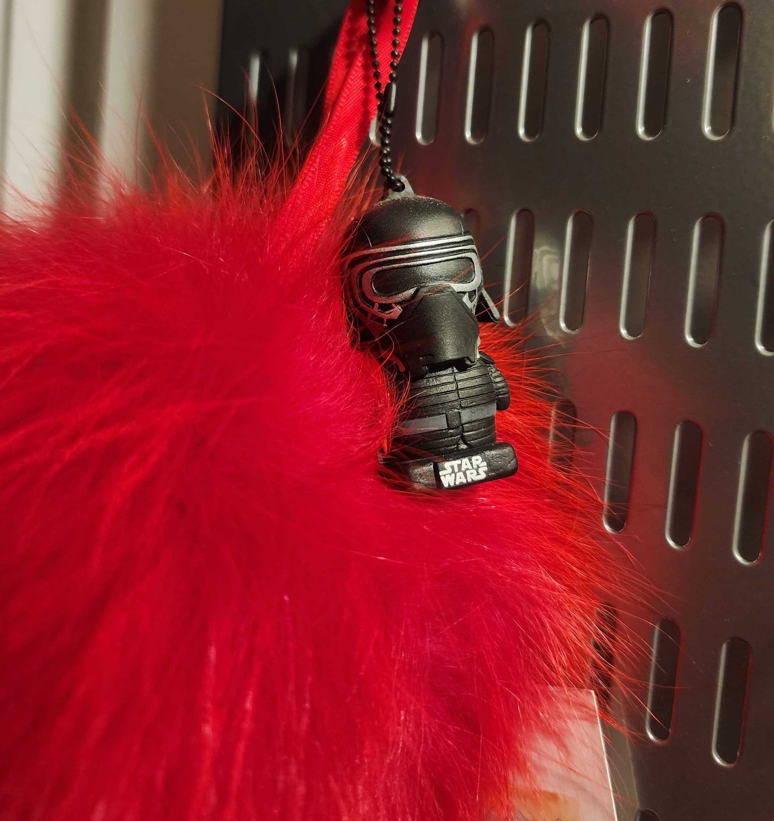 Photograph of a Kylo Ren USB drive in front of a red fake fur item.